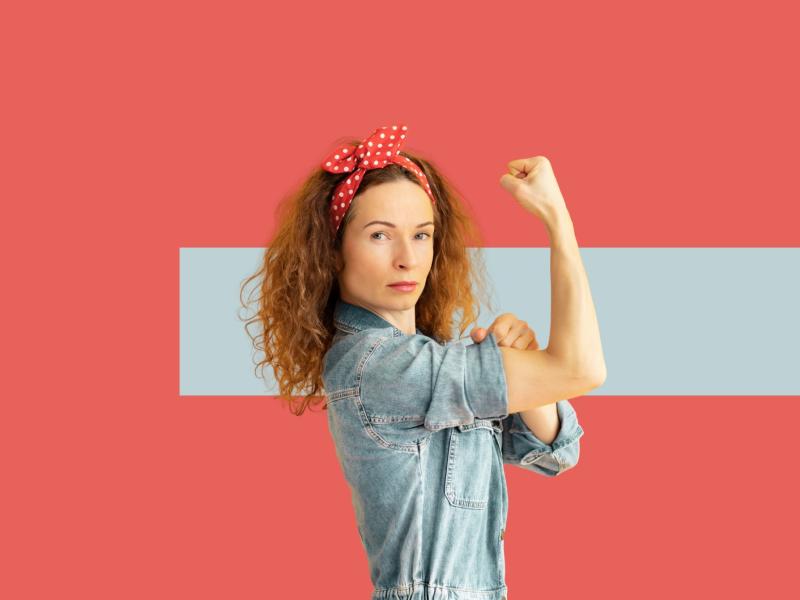 Kvinde viser stærk arm og knyttet næve